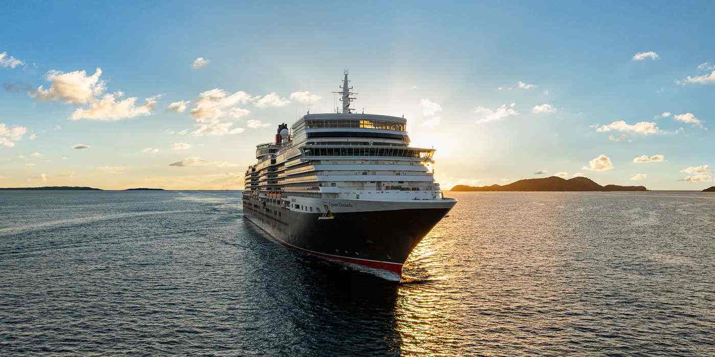 Cruise ship arriving in British Virgin Islands waters at golden hour, aerial view