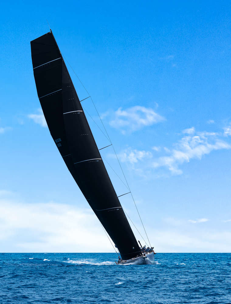 Racing yacht with black sails heeling off Tortola, British Virgin Islands